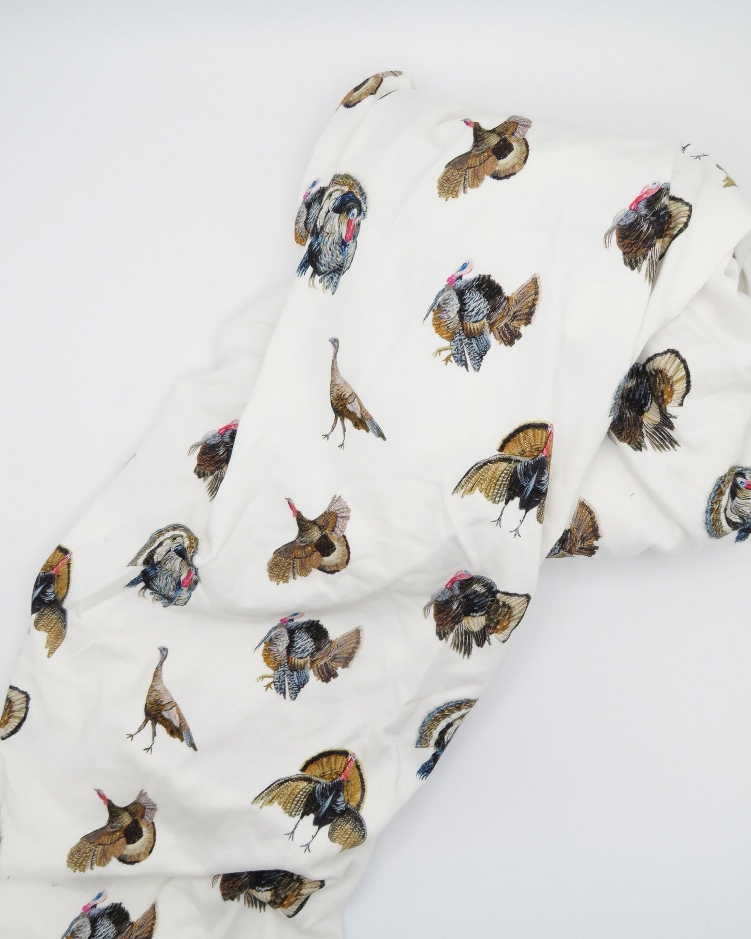 Adorable Turkey Trot crib sheet in soft white jersey cotton, featuring playful turkeys. Displayed on a white background, highlighting cozy and stylish nursery décor—perfect for a turkey-themed nursery.