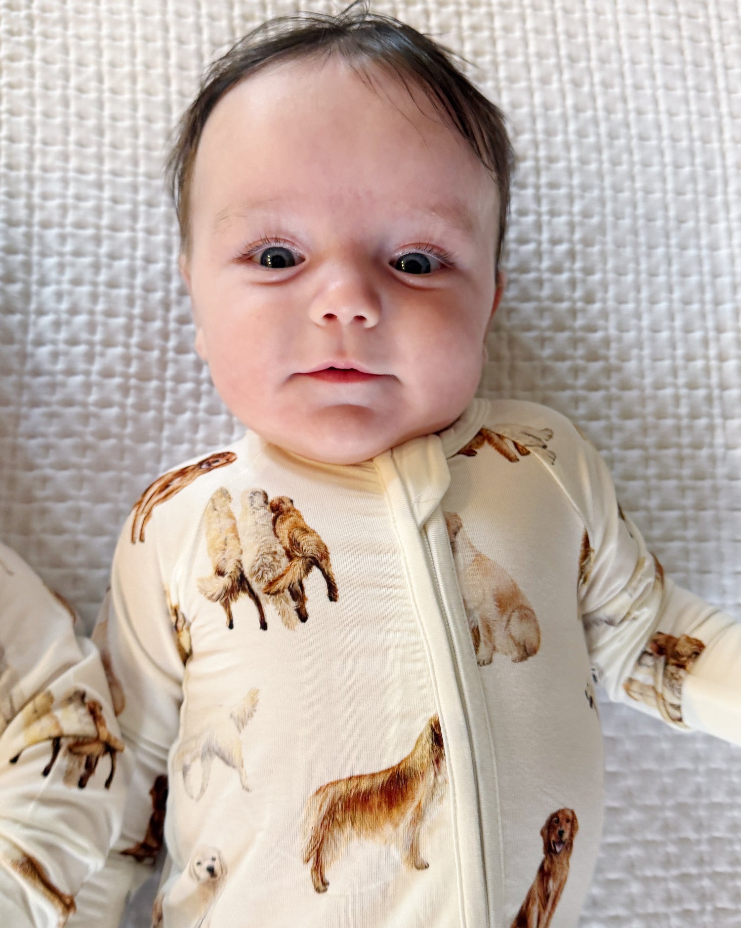 Soft white baby footie pajamas featuring a golden retriever print, with convertible feet designed for comfortable indoor and outdoor wear.