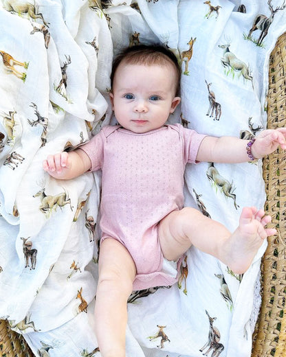 Little Fawn, Big Yawn Deer hand-painted swaddle with bucks, does, and fawn, perfect for your little sportsman or sportswoman, made from soft 30% white organic cotton and 70% bamboo blend. Used by a baby.