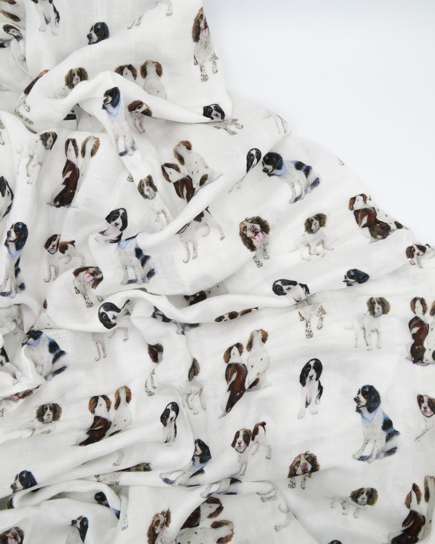 Springer Spaniel print baby swaddle blanket. Gender-neutral dog-themed swaddle for newborns. Springer Spaniel dogs printed on soft white fabric.