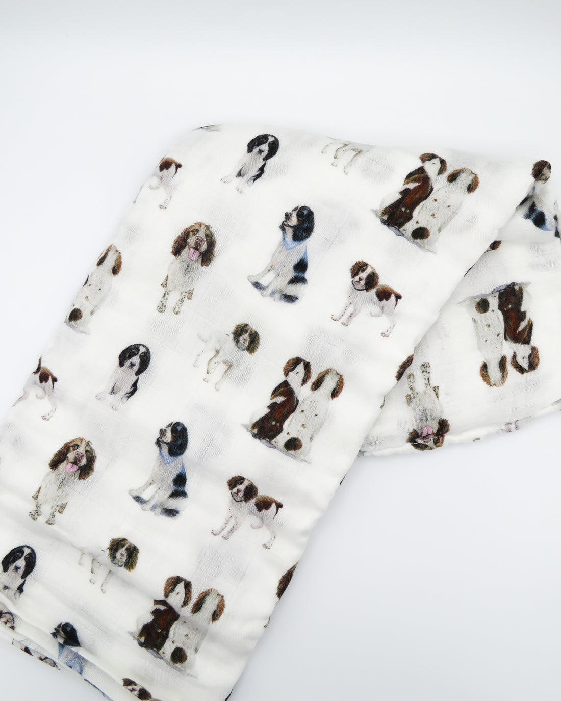 Springer Spaniel print baby swaddle blanket. Gender-neutral dog-themed swaddle for newborns. Springer Spaniel dogs printed on soft white fabric.