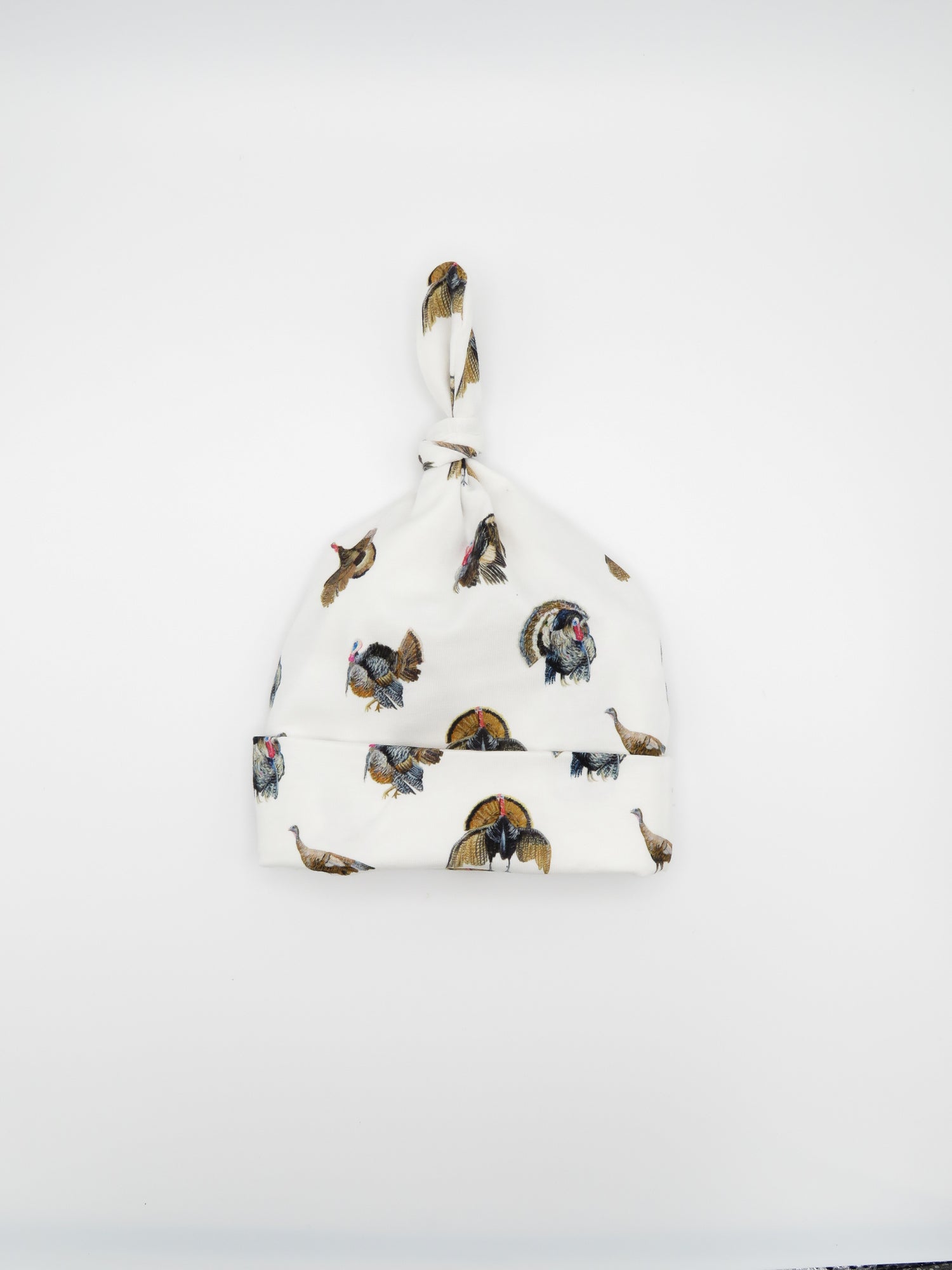 Newborn hat featuring a festive Turkey Trot print displayed on white background, perfect for celebrating the season and a great addition to your newborn&