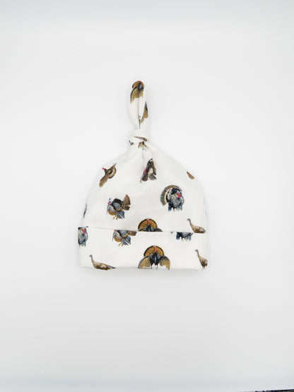 Newborn hat featuring a festive Turkey Trot print displayed on white background, perfect for celebrating the season and a great addition to your newborn&
