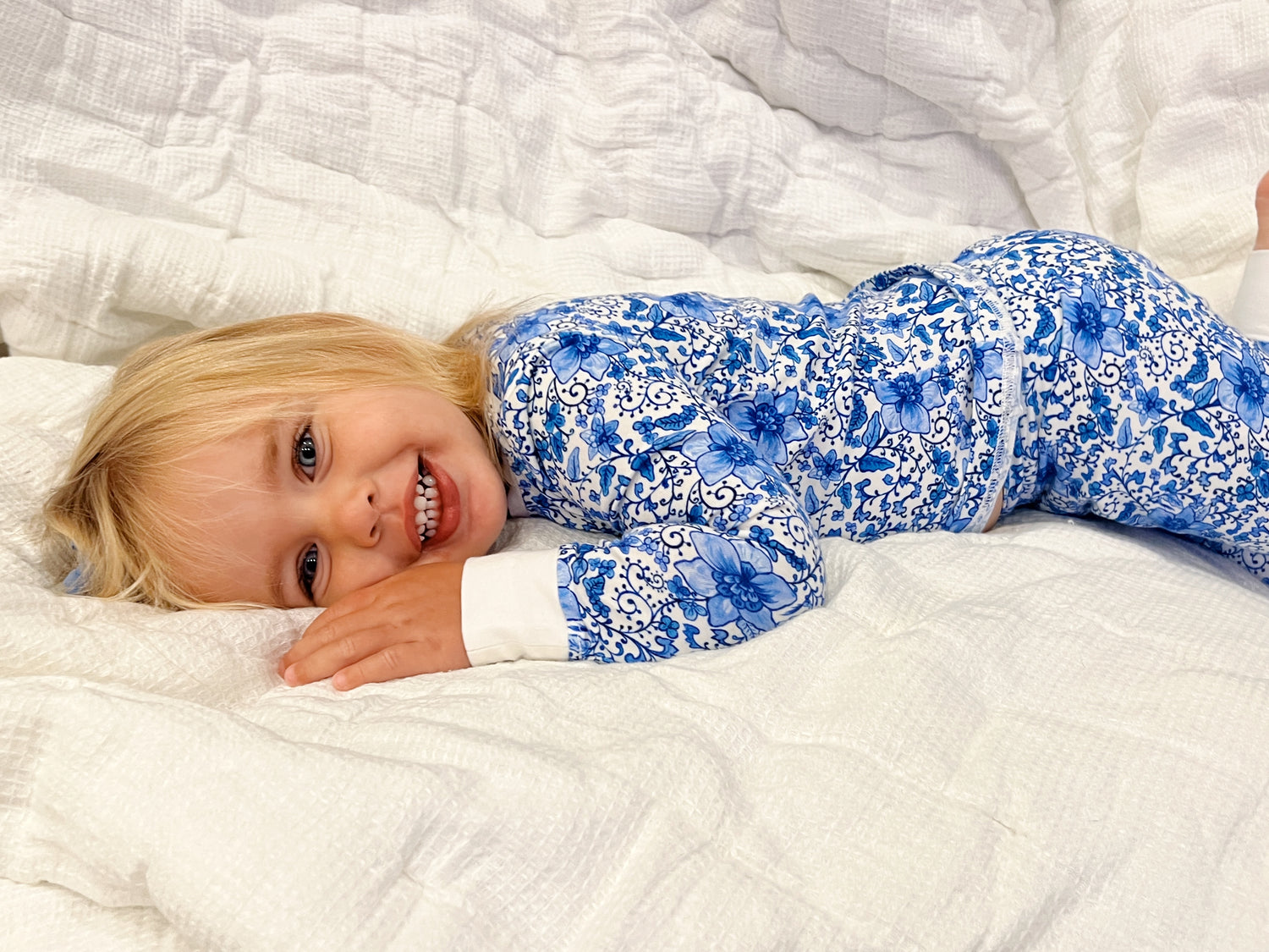 Charming Chinoiserie pajamas in soft white cotton, suitable for indoor or outdoor wear, worn by a young girl indoors.
