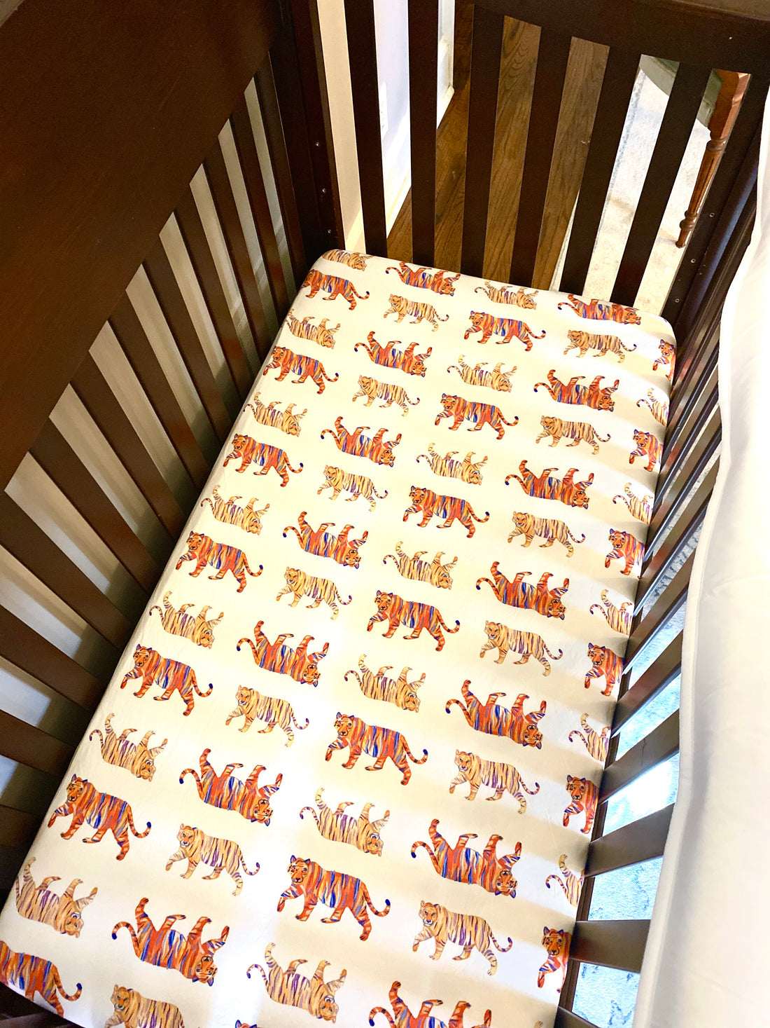 Easy Tiger crib sheet with playful tiger print on soft white jersey cotton fabric. Breathable and gentle, perfect for nurseries, crib sleep, and cozy nap time.